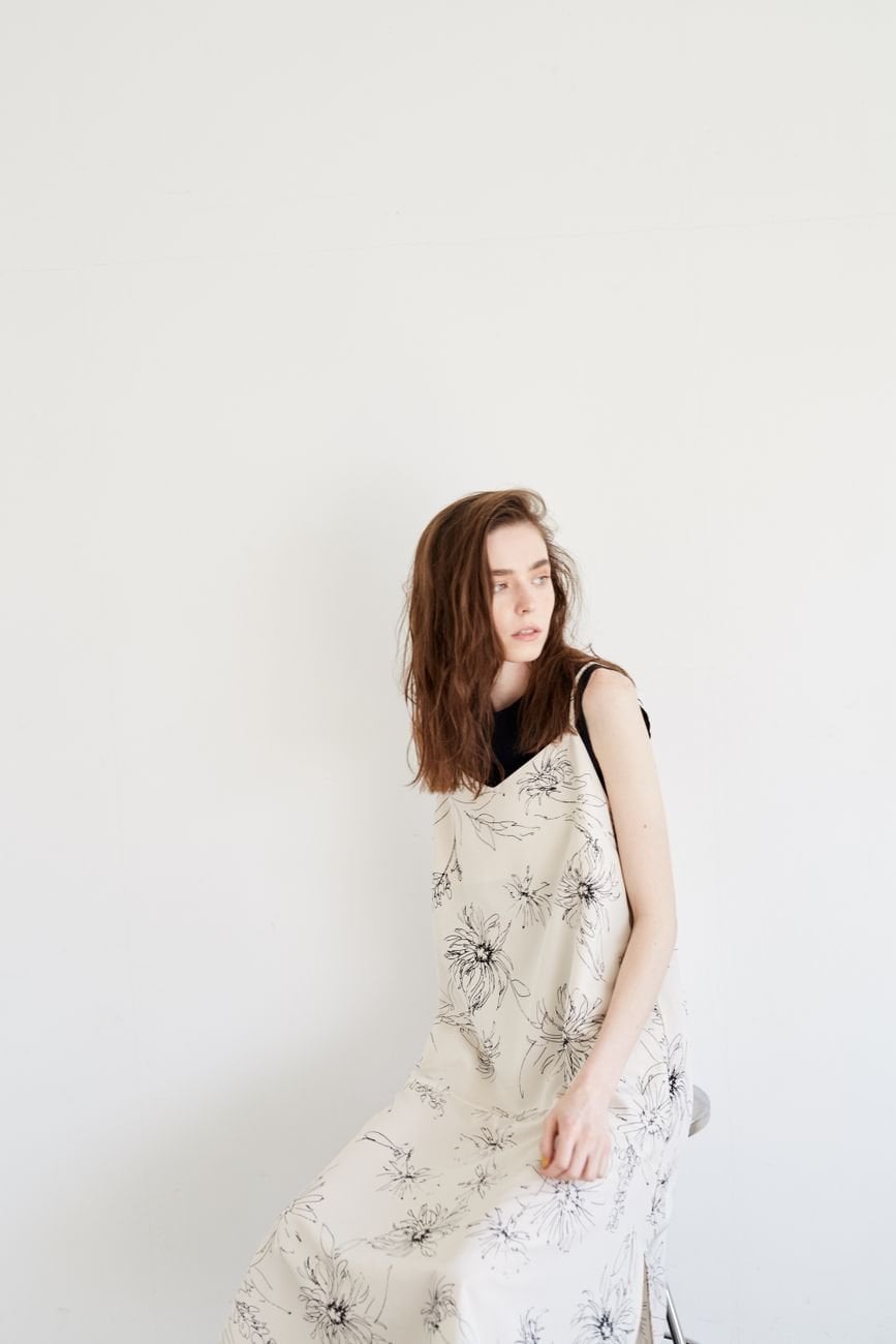 A woman in an elegant minimal dress against a clean white background